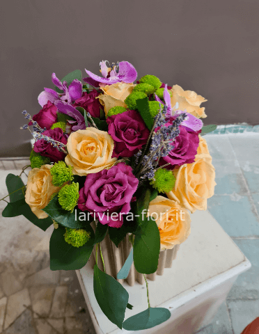 Cestino di vimini o ciotola di ceramica, composto da rose e verde pregiato.